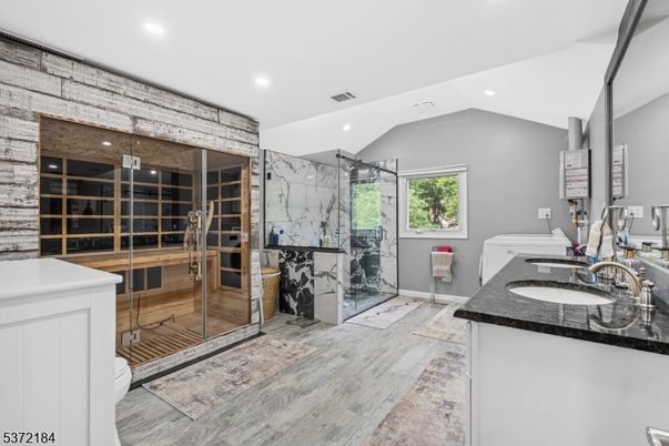 Bathroom, Dual Sink Vanities, Glass Shower, Interior, Marble Walls, Recessed Lighting, Wood Texture Flooring