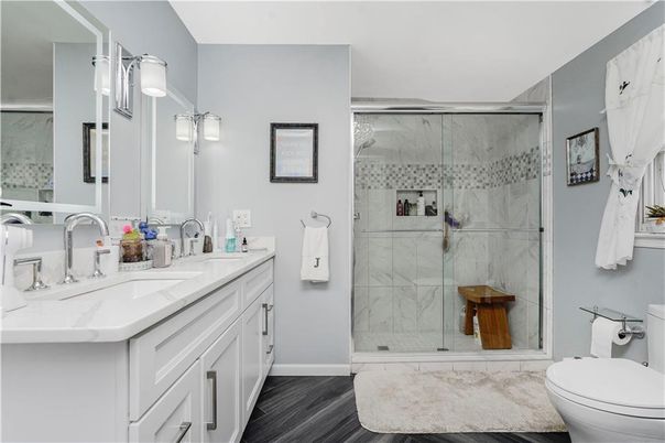 Bathroom, Dual Sink Vanities, Glass Shower, Interior, Marble Walls, Wood Texture Flooring