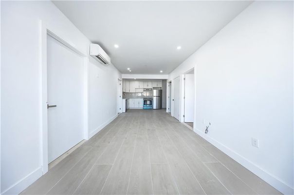 Empty room, Interior, Kitchen, Recessed Lighting, Stainless Steel Appliances, Wood Texture Flooring
