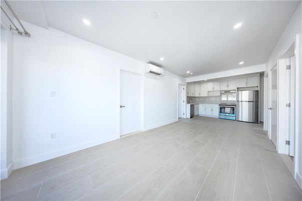Empty room, Interior, Kitchen, Recessed Lighting, Stainless Steel Appliances, Wood Texture Flooring