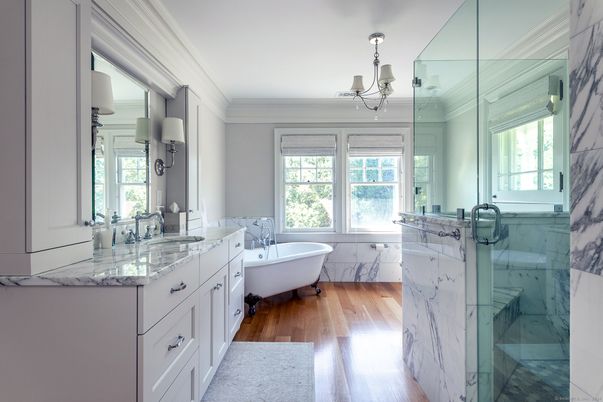 Bathroom, Chandelier, Dual Sink Vanities, Free Standing Baths, Glass Shower, Interior, Marble, Marble Walls, Wood Texture Flooring