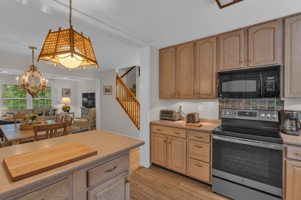 Chandelier, Dining room, Interior, Kitchen, Living room, Pendant Lights, Stainless Steel Appliances, Wood Texture Flooring