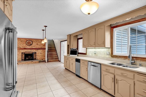 Fireplace, Interior, Kitchen, Pendant Lights, Stainless Steel Appliances, Stone Walls