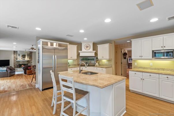 Fireplace, Interior, Kitchen, Recessed Lighting, Stainless Steel Appliances, Stone Walls, Wood Texture Flooring