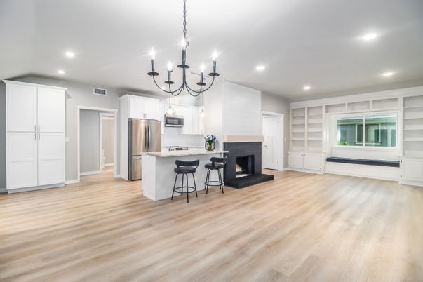 Chandelier, Empty room, Fireplace, Interior, Kitchen, Recessed Lighting, Stainless Steel Appliances, Wood Texture Flooring