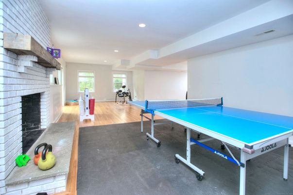 Fireplace, Game Room, Interior, Recessed Lighting, Stone Walls, Wood Texture Flooring