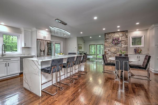 Chandelier, Dining room, Interior, Kitchen, Recessed Lighting, Stainless Steel Appliances, Stone Walls, Wood Texture Flooring