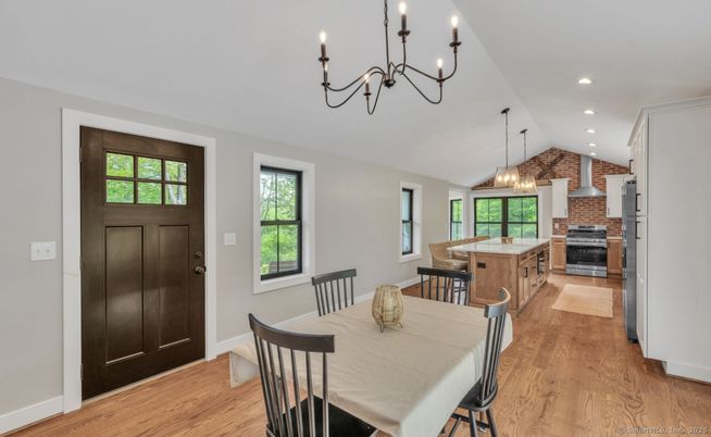 Chandelier, Dining room, Fireplace, Interior, Kitchen, Pendant Lights, Recessed Lighting, Stainless Steel Appliances, Stone Walls, Wood Texture Flooring