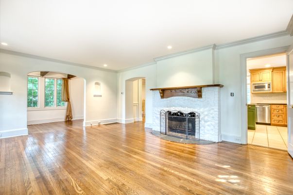 Empty room, Fireplace, Interior, Kitchen, Recessed Lighting, Stainless Steel Appliances, Wood Texture Flooring