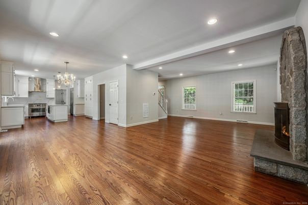 Chandelier, Empty room, Fireplace, Interior, Kitchen, Recessed Lighting, Stainless Steel Appliances, Wood Texture Flooring
