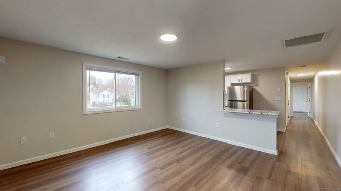 Empty room, Interior, Kitchen, Recessed Lighting, Stainless Steel Appliances, Wood Texture Flooring
