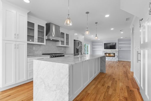 Fireplace, Interior, Kitchen, Marble Walls, Pendant Lights, Recessed Lighting, Stainless Steel Appliances, Wood Texture Flooring