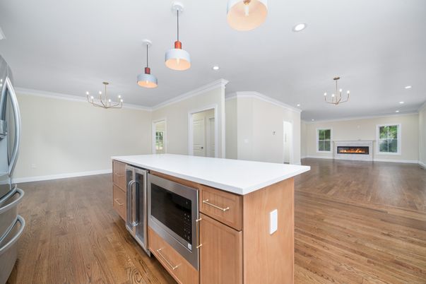 Chandelier, Empty room, Fireplace, Interior, Kitchen, Pendant Lights, Recessed Lighting, Stainless Steel Appliances, Wood Texture Flooring