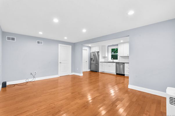 Empty room, Interior, Kitchen, Recessed Lighting, Stainless Steel Appliances, Wood Texture Flooring