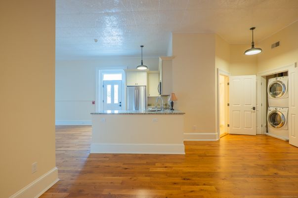 Empty room, Interior, Kitchen, Pendant Lights, Stainless Steel Appliances, Utility Closets, Washer, Wood Texture Flooring