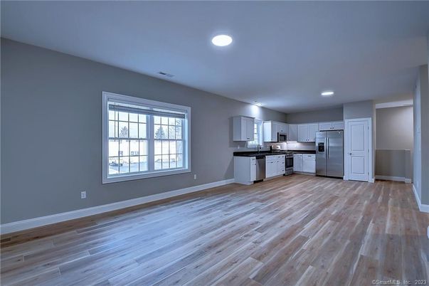 Empty room, Interior, Kitchen, Recessed Lighting, Stainless Steel Appliances, Wood Texture Flooring