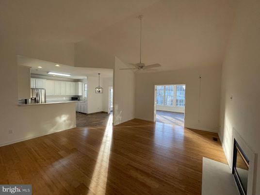 Empty room, Fireplace, Interior, Kitchen, Pendant Lights, Recessed Lighting, Stainless Steel Appliances, Wood Texture Flooring