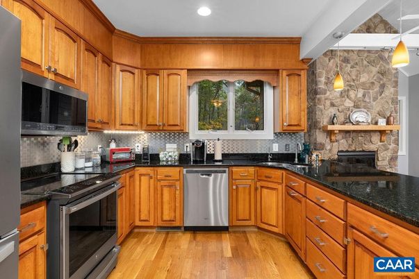 Fireplace, Interior, Kitchen, Pendant Lights, Recessed Lighting, Stainless Steel Appliances, Stone Walls, Wood Texture Flooring
