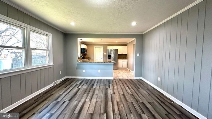Empty room, Interior, Kitchen, Recessed Lighting, Stainless Steel Appliances, Wood Texture Flooring