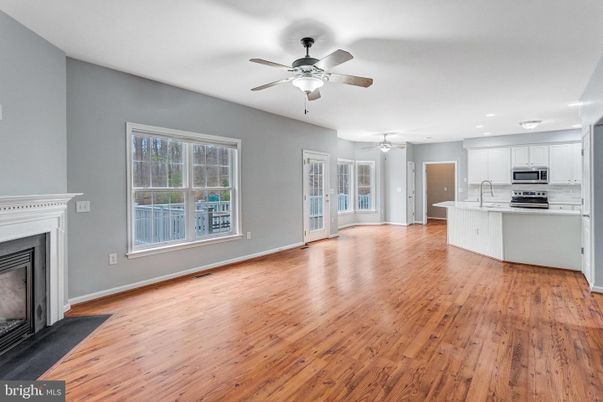 Empty room, Fireplace, Interior, Kitchen, Recessed Lighting, Stainless Steel Appliances, Wood Texture Flooring