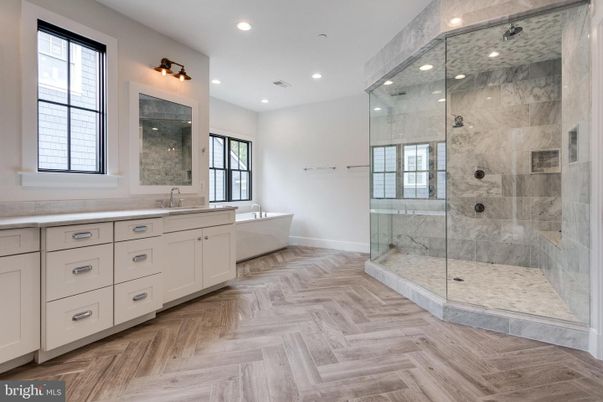 Bathroom, Dual Sink Vanities, Free Standing Baths, Glass Shower, Interior, Marble Walls, Recessed Lighting, Wood Texture Flooring