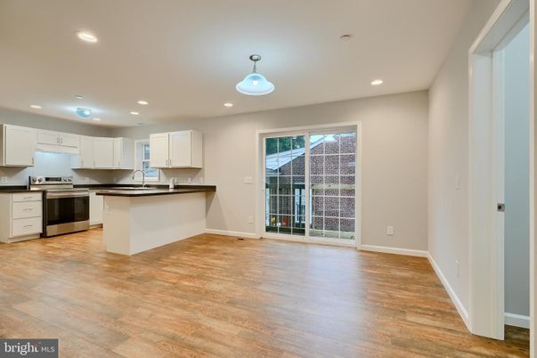 Empty room, Interior, Kitchen, Recessed Lighting, Stainless Steel Appliances, Wood Texture Flooring