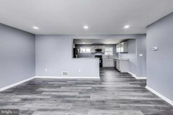 Empty room, Interior, Kitchen, Recessed Lighting, Stainless Steel Appliances, Wood Texture Flooring