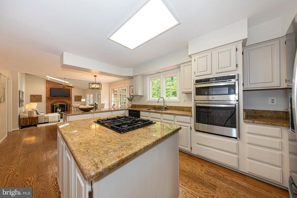 Chandelier, Fireplace, Interior, Kitchen, Living room, Pendant Lights, Recessed Lighting, Stainless Steel Appliances, Wood Texture Flooring