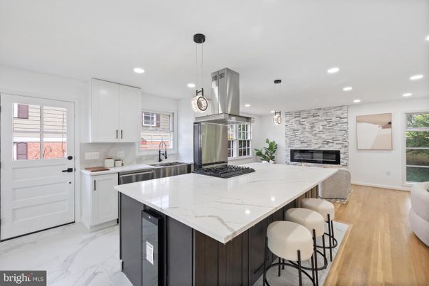 Fireplace, Interior, Kitchen, Marble, Pendant Lights, Recessed Lighting, Stainless Steel Appliances, Stone Walls, Wood Texture Flooring