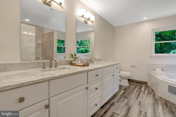Bathroom, Dual Sink Vanities, Interior, Marble Walls, Recessed Lighting, Wood Texture Flooring