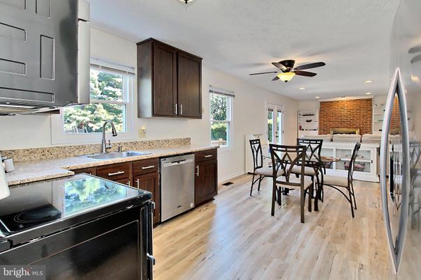 Dining room, Fireplace, Interior, Kitchen, Recessed Lighting, Stainless Steel Appliances, Stone Walls, Wood Texture Flooring