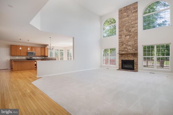 Empty room, Fireplace, Interior, Kitchen, Pendant Lights, Stainless Steel Appliances, Wood Texture Flooring