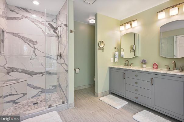 Bathroom, Dual Sink Vanities, Glass Shower, Interior, Marble Walls, Recessed Lighting, Wood Texture Flooring