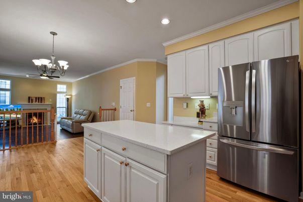 Chandelier, Fireplace, Interior, Kitchen, Living room, Pendant Lights, Recessed Lighting, Stainless Steel Appliances, Wood Texture Flooring