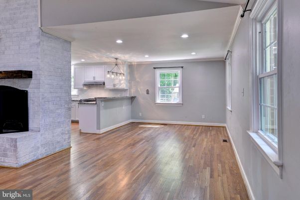 Empty room, Fireplace, Interior, Kitchen, Pendant Lights, Recessed Lighting, Stainless Steel Appliances, Stone Walls, Wood Texture Flooring