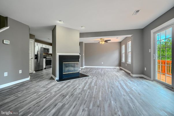 Empty room, Fireplace, Interior, Kitchen, Recessed Lighting, Stainless Steel Appliances, Wood Texture Flooring