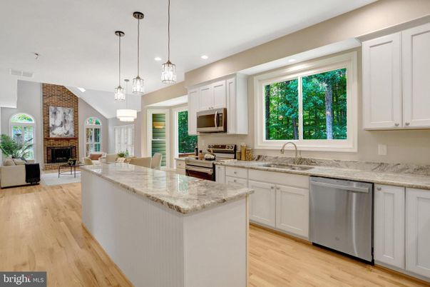 Fireplace, Interior, Kitchen, Living room, Pendant Lights, Recessed Lighting, Stainless Steel Appliances, Stone Walls, Wood Texture Flooring