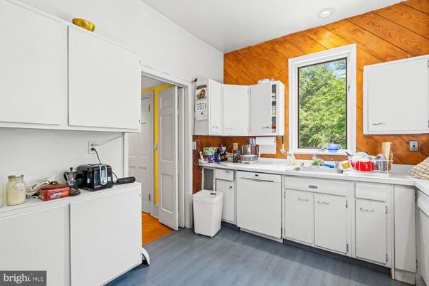 Interior, Kitchen, Recessed Lighting, Washer, Wood Texture Flooring, Wooden Walls