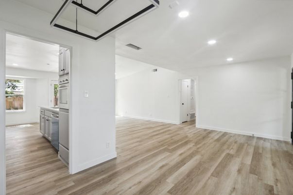 Empty room, Interior, Kitchen, Recessed Lighting, Stainless Steel Appliances, Wood Texture Flooring