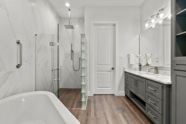 Bathroom, Dual Sink Vanities, Free Standing Baths, Glass Shower, Interior, Marble Walls, Recessed Lighting, Wood Texture Flooring
