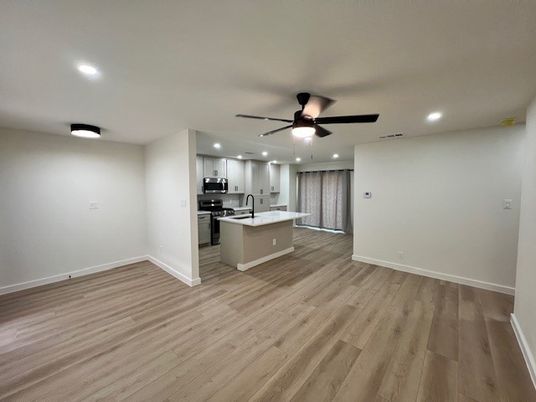 Empty room, Interior, Kitchen, Recessed Lighting, Stainless Steel Appliances, Wood Texture Flooring