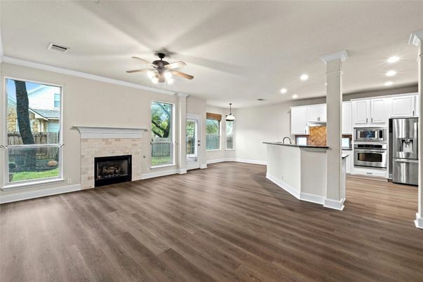 Empty room, Fireplace, Interior, Kitchen, Pendant Lights, Recessed Lighting, Stainless Steel Appliances, Wood Texture Flooring