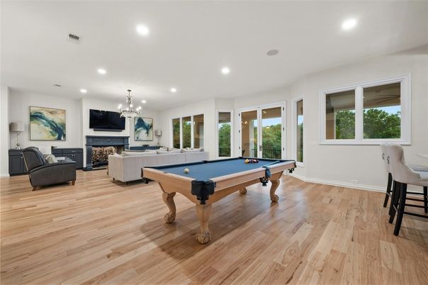 Billiard Table, Chandelier, Fireplace, Game Room, Interior, Living room, Recessed Lighting, Wood Texture Flooring