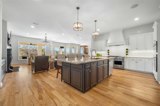 Chandelier, Fireplace, Interior, Kitchen, Living room, Pendant Lights, Recessed Lighting, Stainless Steel Appliances, Wood Texture Flooring