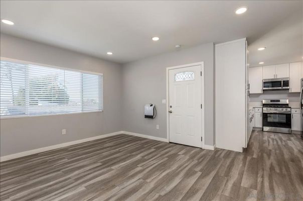 Empty room, Interior, Kitchen, Recessed Lighting, Stainless Steel Appliances, Wood Texture Flooring