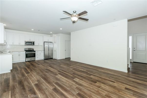 Empty room, Interior, Kitchen, Recessed Lighting, Stainless Steel Appliances, Wood Texture Flooring