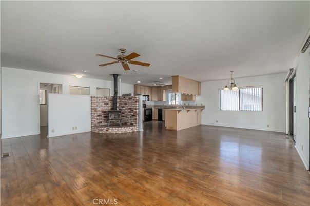 Empty room, Fireplace, Interior, Kitchen, Recessed Lighting, Stainless Steel Appliances, Stone Walls, Wood Texture Flooring