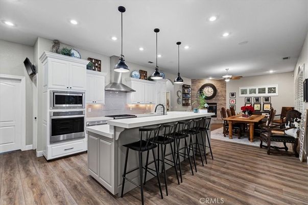 Dining room, Fireplace, Interior, Kitchen, Pendant Lights, Recessed Lighting, Stainless Steel Appliances, Stone Walls, Wood Texture Flooring