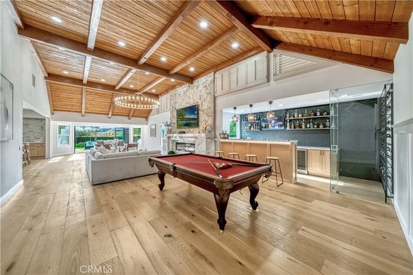Billiard Table, Chandelier, Fireplace, Game Room, Interior, Living room, Pendant Lights, Recessed Lighting, Stone Walls, Wooden Beams, Wooden Ceilings, Wood Texture Flooring