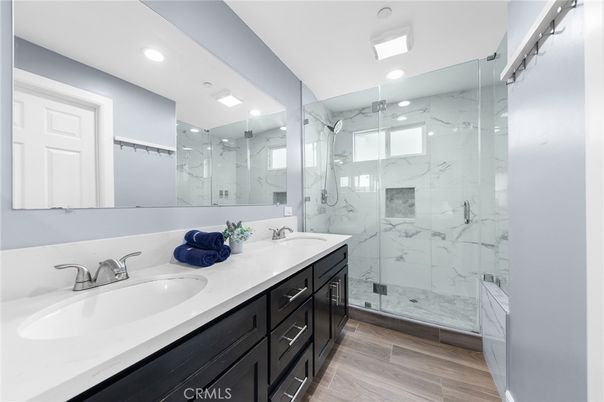 Bathroom, Dual Sink Vanities, Glass Shower, Interior, Marble Walls, Recessed Lighting, Wood Texture Flooring